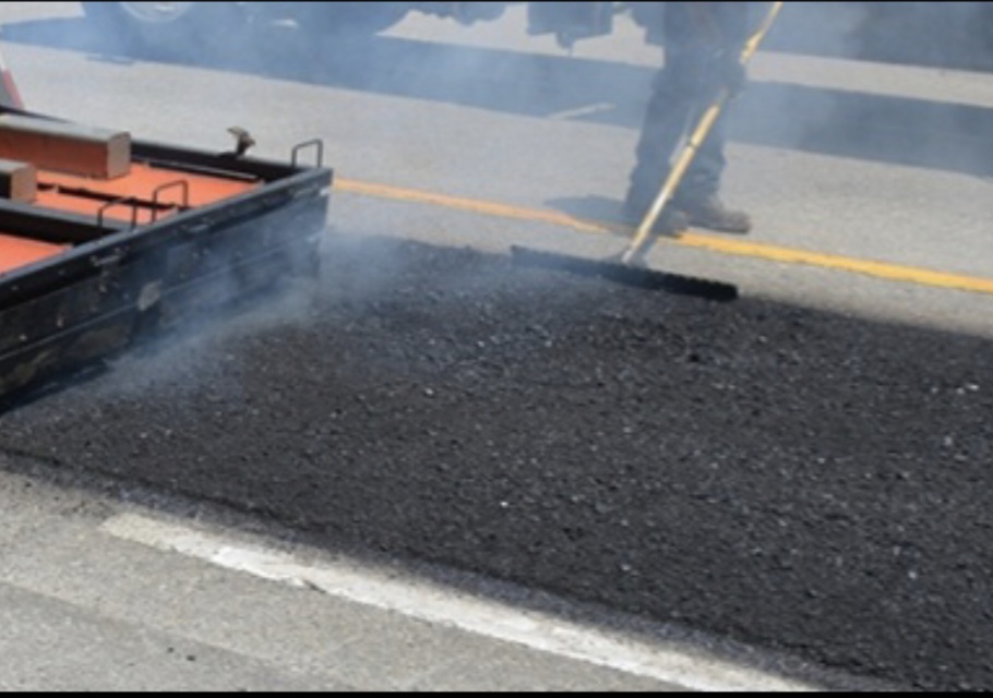 Steam rising from thermally heated asphalt